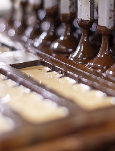 Dépôt du chocolat dans les moules sur la ligne de production Choc and Co