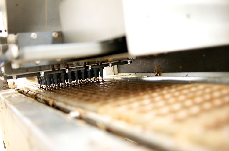 Dépose de chocolat dans les moules sur notre ligne de production